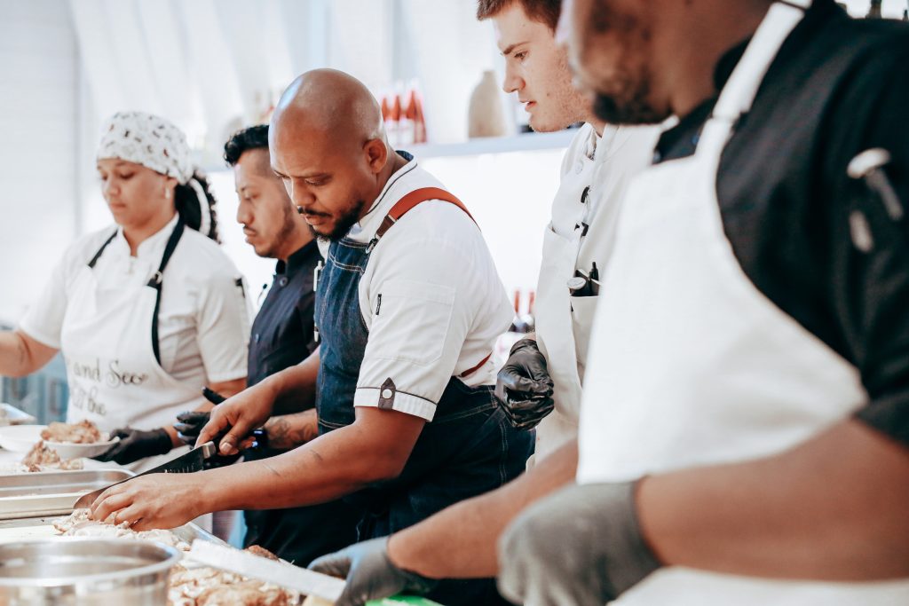 Chef and students preparing food to be served 